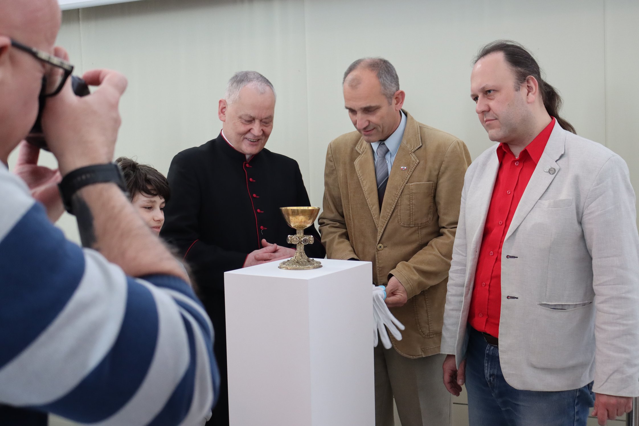 Propst Grzegorz Legutko und die Stettiner Historiker Dr. Piotr Briks und Dr. Paweł Migdalski betrachten den Naugarder Kelch (Foto: J. Kruse).
