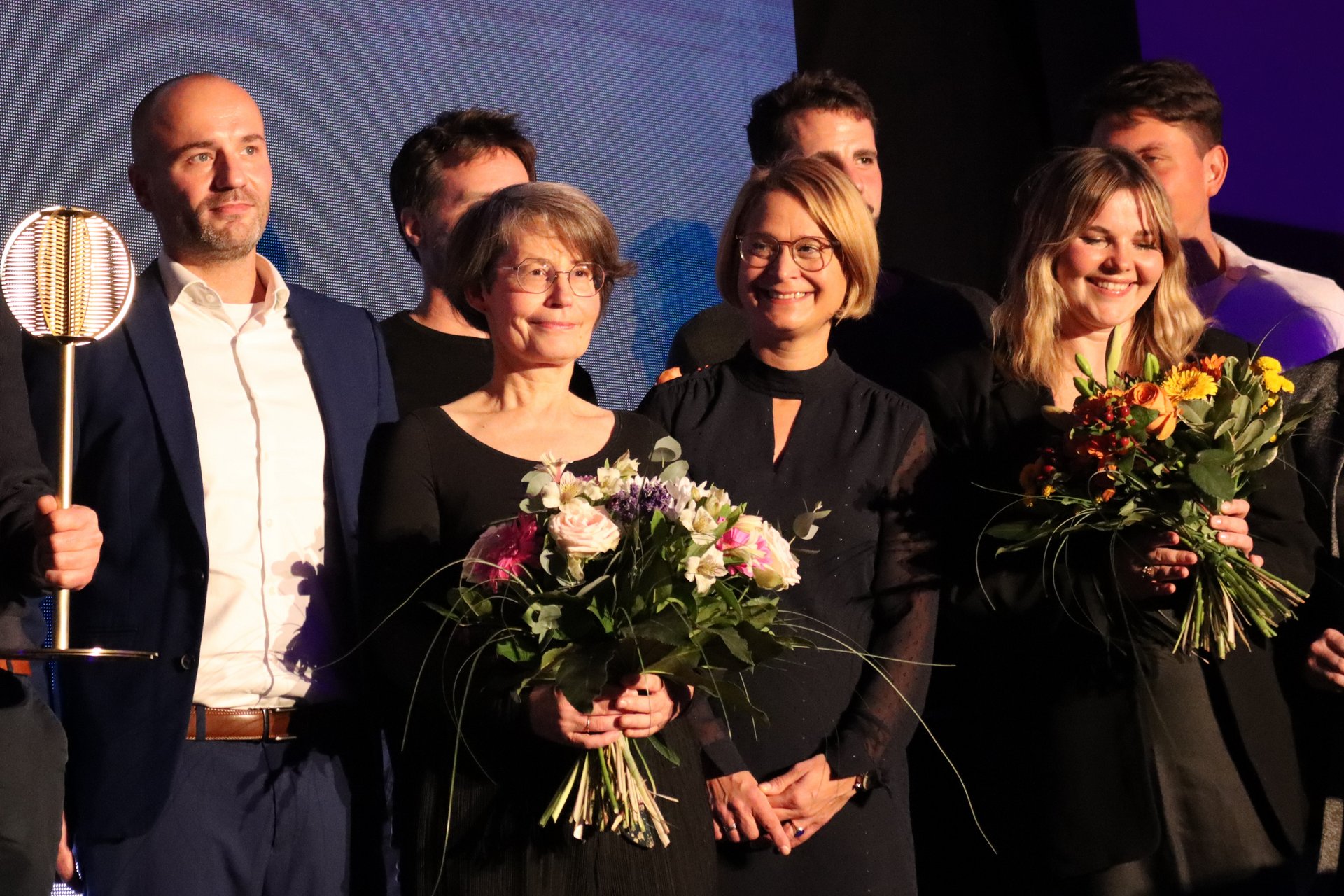 Auf der Bühne: Dr. Birte Frenssen neben Birgit Hesse inmitten der anderen Preisträgerinnen und Preisträger. Detail eines größeren Gruppenbildes.
